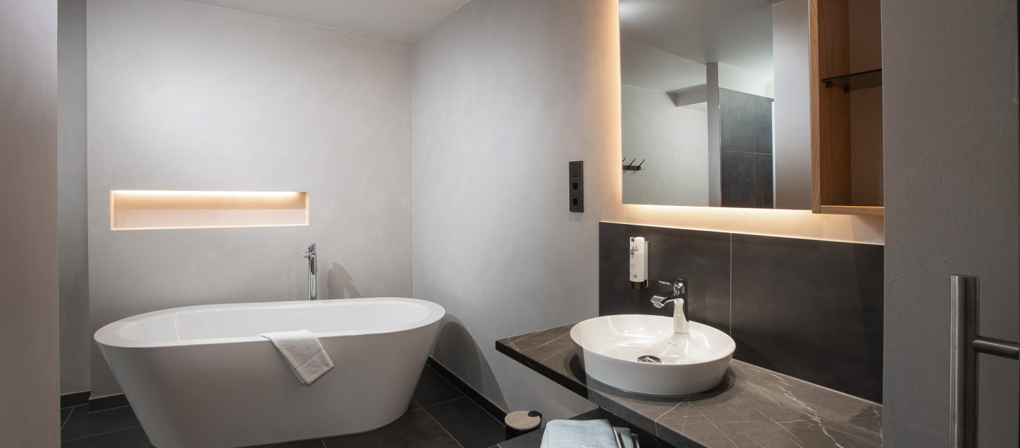 Eine freistehende Badewanne in dem modernen Badezimmer des Basic Studios